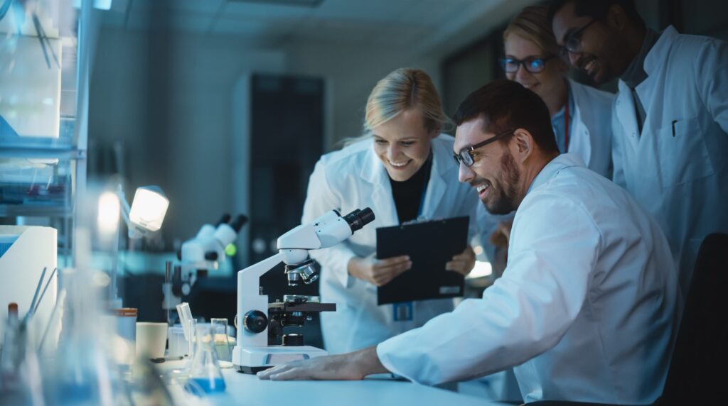 A team of Scientists gather around the lab in happiness upon discovering something amazing