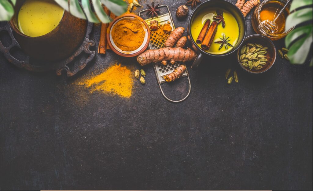 Healthy Ayurvedic ingredients: turmeric roots , spices and honey on a dark background.