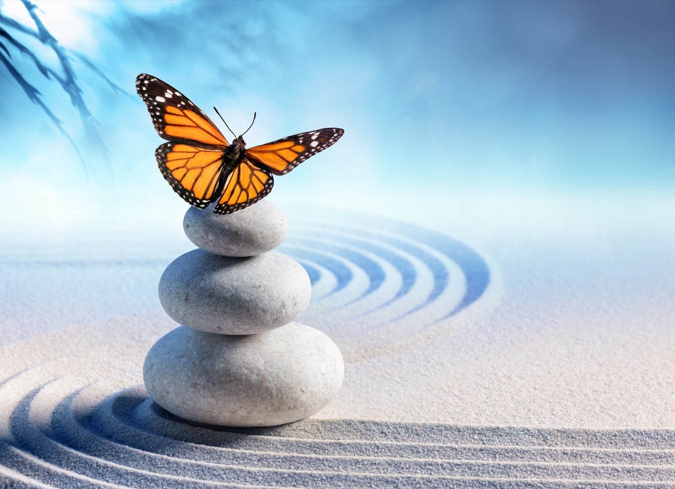 Balanced pebbles with a butterfly in a warm blue silhouette