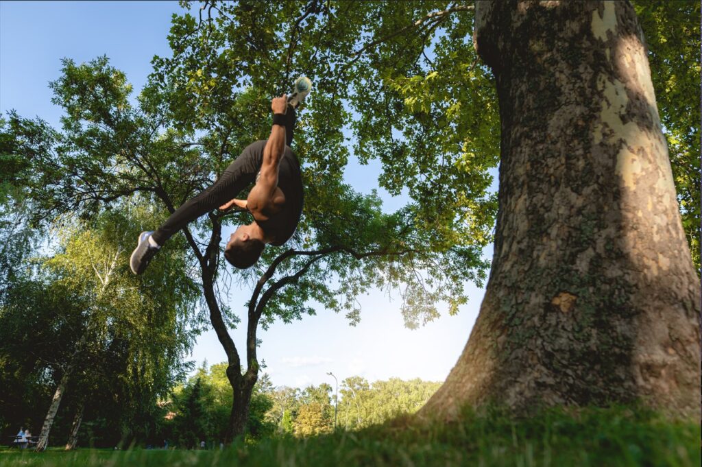 Man performing gymnastics by doing a backflip at the park