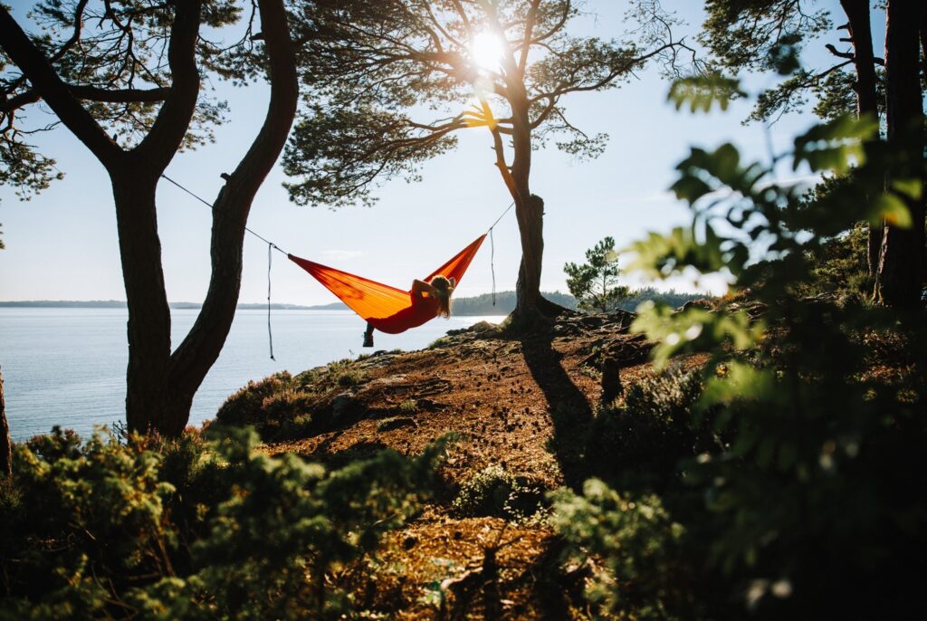 Person relaxing on a hammock in the forest, looking up a river. 