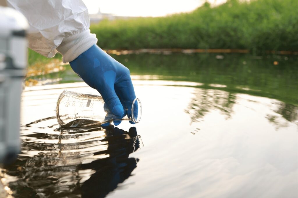 Close up of Environment engineer Collect samples of wastewater from industrial canals in test tube