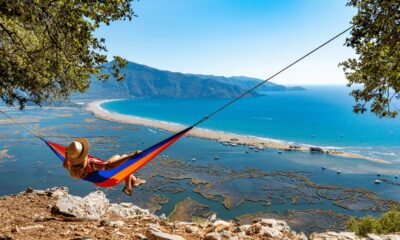 Woman lying in the hammock is looking at the beach