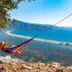 Woman lying in the hammock is looking at the beach
