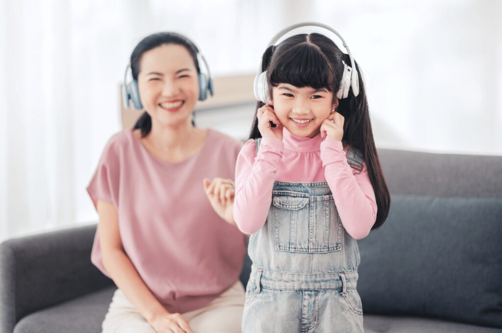 A happy mother and her child listening with headphones on