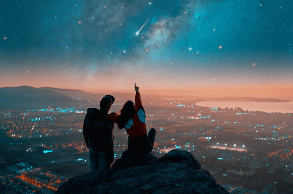 Silhouette of a couple looking up at the stars 