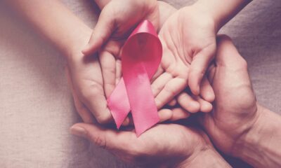 Family holding pink ribbon for breast cancer awareness
