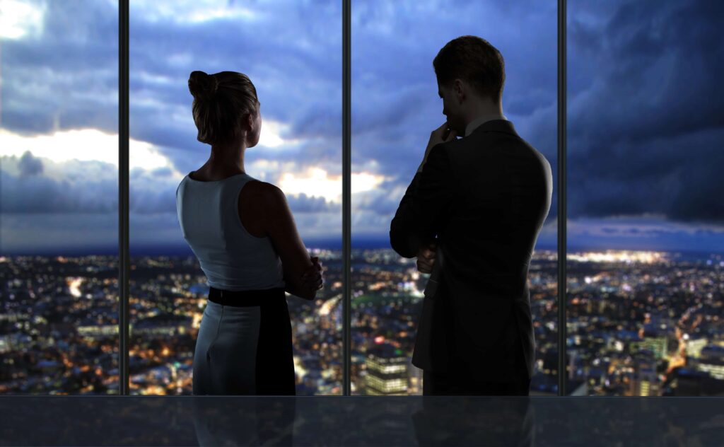 What to Consider When Deciding to Be an Entrepreneur: a man and woman looking at a city from a business tower